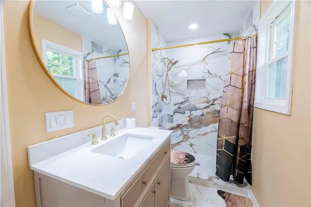 a bathroom with a sink toilet and shower