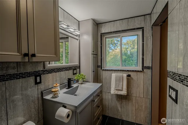 a bathroom with a sink vanity granite and a mirror