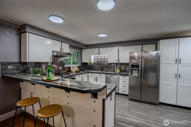 a kitchen with stainless steel appliances a sink stove and refrigerator