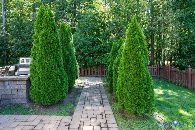 a view of a backyard with a trees and wooden fence