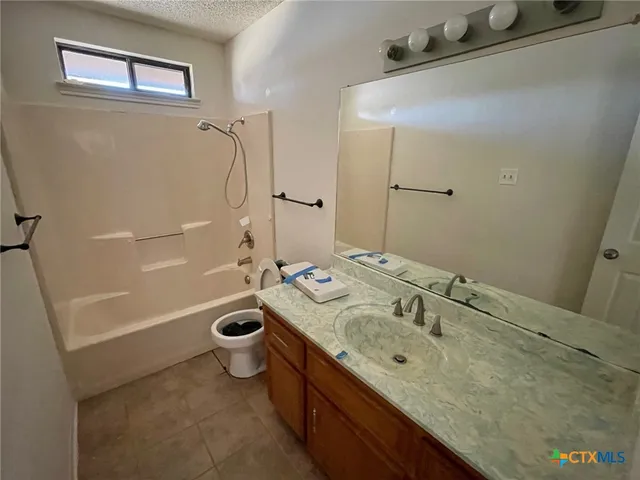 a bathroom with a granite countertop sink a toilet and shower