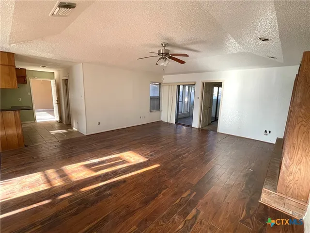 a view of a livingroom with wooden floor and a ceiling fan