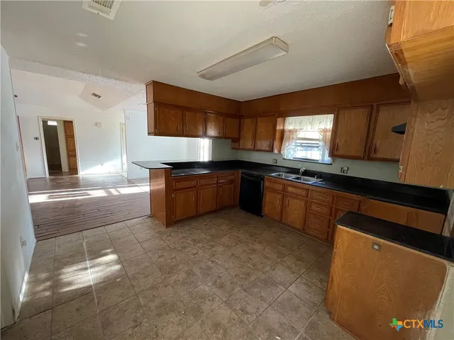 a kitchen with stainless steel appliances granite countertop a sink and a stove