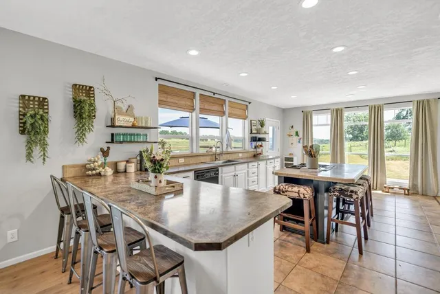 a kitchen with a stove a refrigerator and a view of dining table