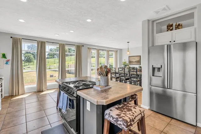 a kitchen with stainless steel appliances granite countertop a sink a stove and a refrigerator