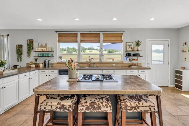 a living room with furniture ceiling fan and a large window