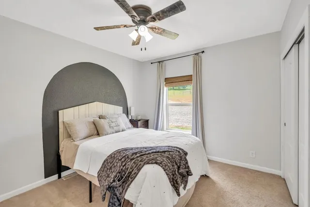 a bedroom with a large bed and a window