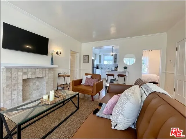 a living room with furniture a fireplace and a window