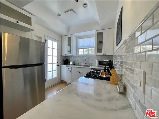 a kitchen with stainless steel appliances a sink dishwasher stove refrigerator and cabinets