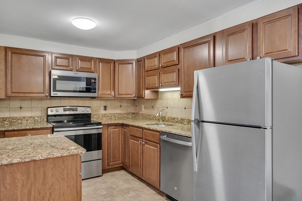 8 Old Colony Lane, Unit 2 Arlington, MA 02476 - Photo 1 of 12 a kitchen with granite countertop stainless steel appliances and refrigerator