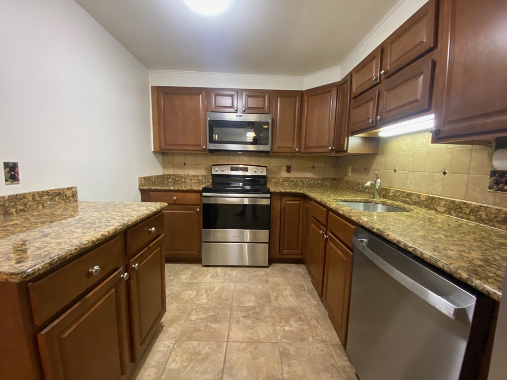 8 Old Colony Lane, Unit 2 Arlington, MA 02476 - Photo 12 of 12 a kitchen with stainless steel appliances granite countertop a stove a sink dishwasher and a refrigerator