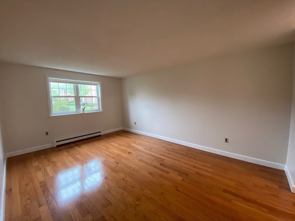 8 Old Colony Lane, Unit 2 Arlington, MA 02476 - Photo 2 of 12 an empty room with wooden floor and windows