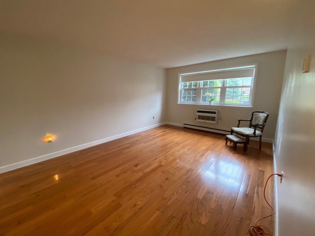 8 Old Colony Lane, Unit 2 Arlington, MA 02476 - Photo 5 of 12 a view of a room with wooden floor a ceiling fan and windows