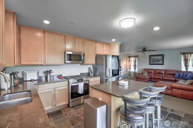 a kitchen with a sink a stove a refrigerator cabinets and chairs