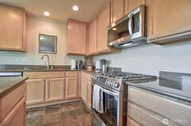 a kitchen with stainless steel appliances granite countertop a sink and a stove