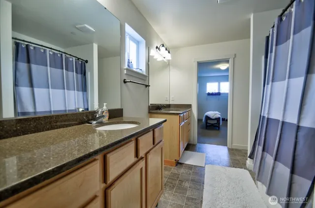 a bathroom with a granite countertop sink and a mirror