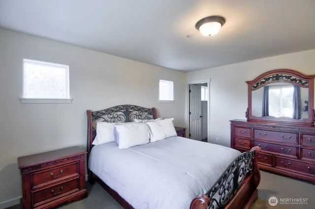 a bedroom with a bed and a dresser with mirror