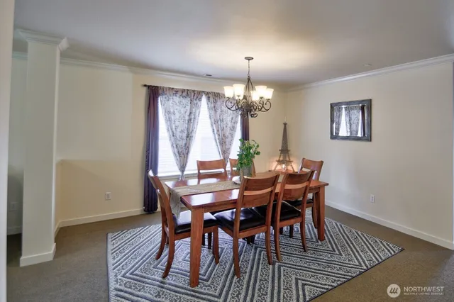 a view of a dining room with furniture a chandelier and wooden floor