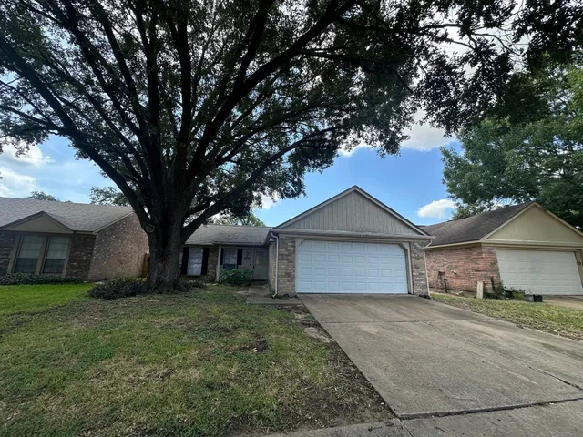 a front view of a house with a garden and trees
