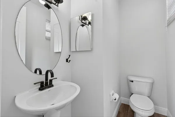 a bathroom with a toilet sink and mirror