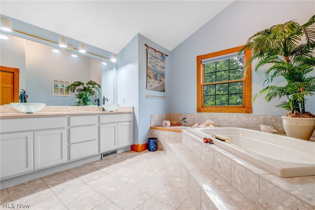 2645 Frost Road Mantua, OH 44255 - Photo 21 of 35 On Suite features vaulted ceiling, a relaxing tiled jacuzzi soaking tub, double glass sinks vanity, and ceramic tile floors