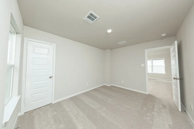 an empty room with windows and closet