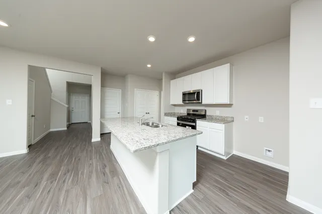 a open kitchen with kitchen island a sink appliances and cabinets