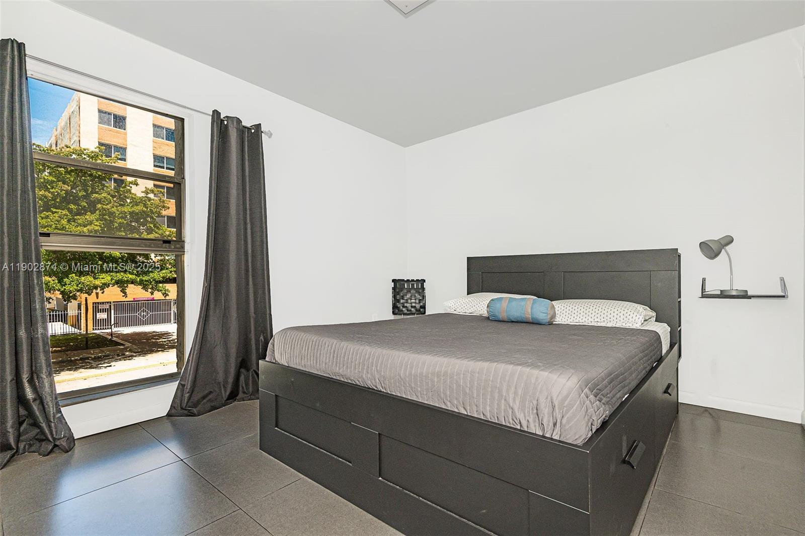 201 178th Drive, Unit 212 Sunny Isles Beach, FL 33160 - Photo 13 of 15 a spacious bedroom with a bed and glass door