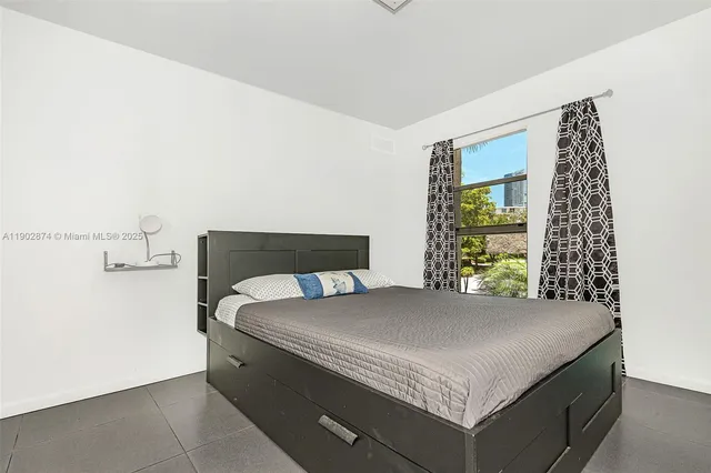 a bed sitting in a bedroom next to a window