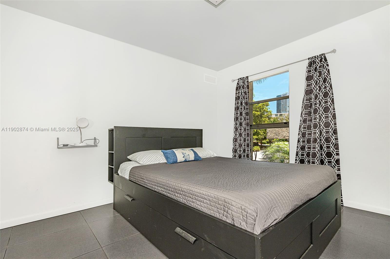 201 178th Drive, Unit 212 Sunny Isles Beach, FL 33160 - Photo 14 of 15 a bed sitting in a bedroom next to a window