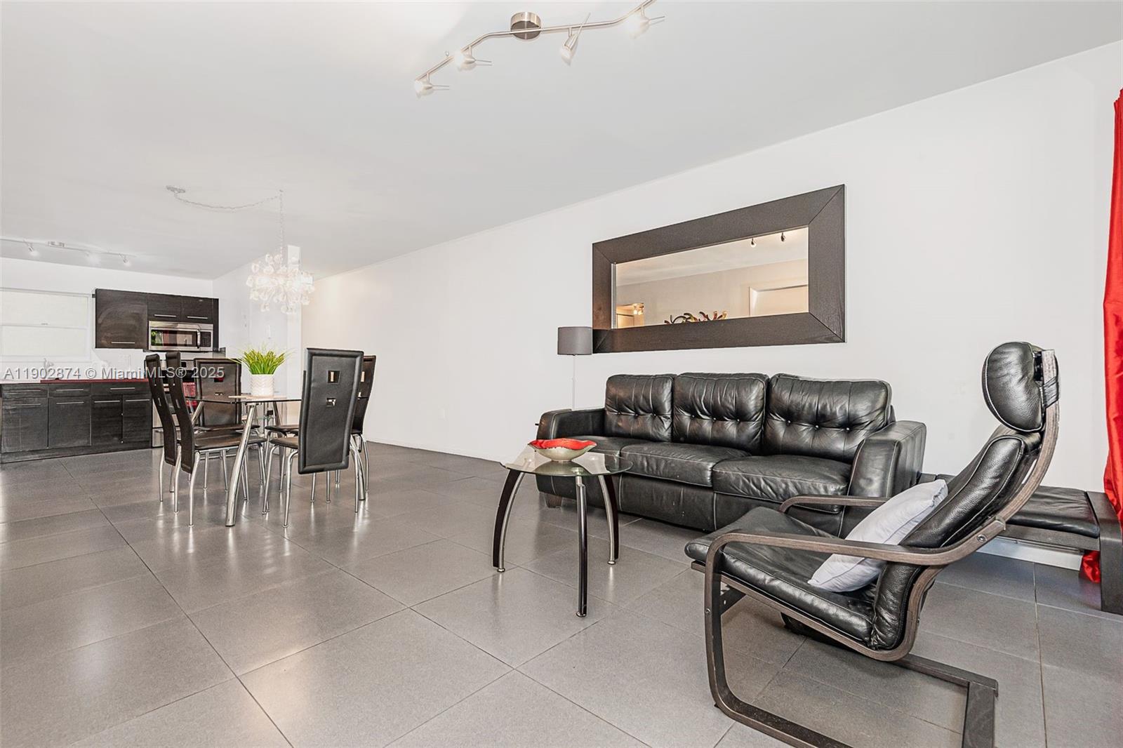 201 178th Drive, Unit 212 Sunny Isles Beach, FL 33160 - Photo 7 of 15 a living room with furniture a wooden floor and a chandelier