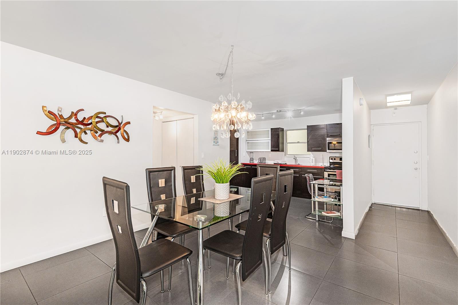 201 178th Drive, Unit 212 Sunny Isles Beach, FL 33160 - Photo 9 of 15 a view of a dining room with furniture and chandelier