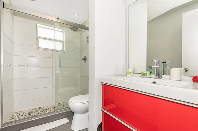 a bathroom with a sink a toilet and shower