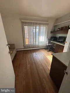 a view of a livingroom with wooden floor and a window