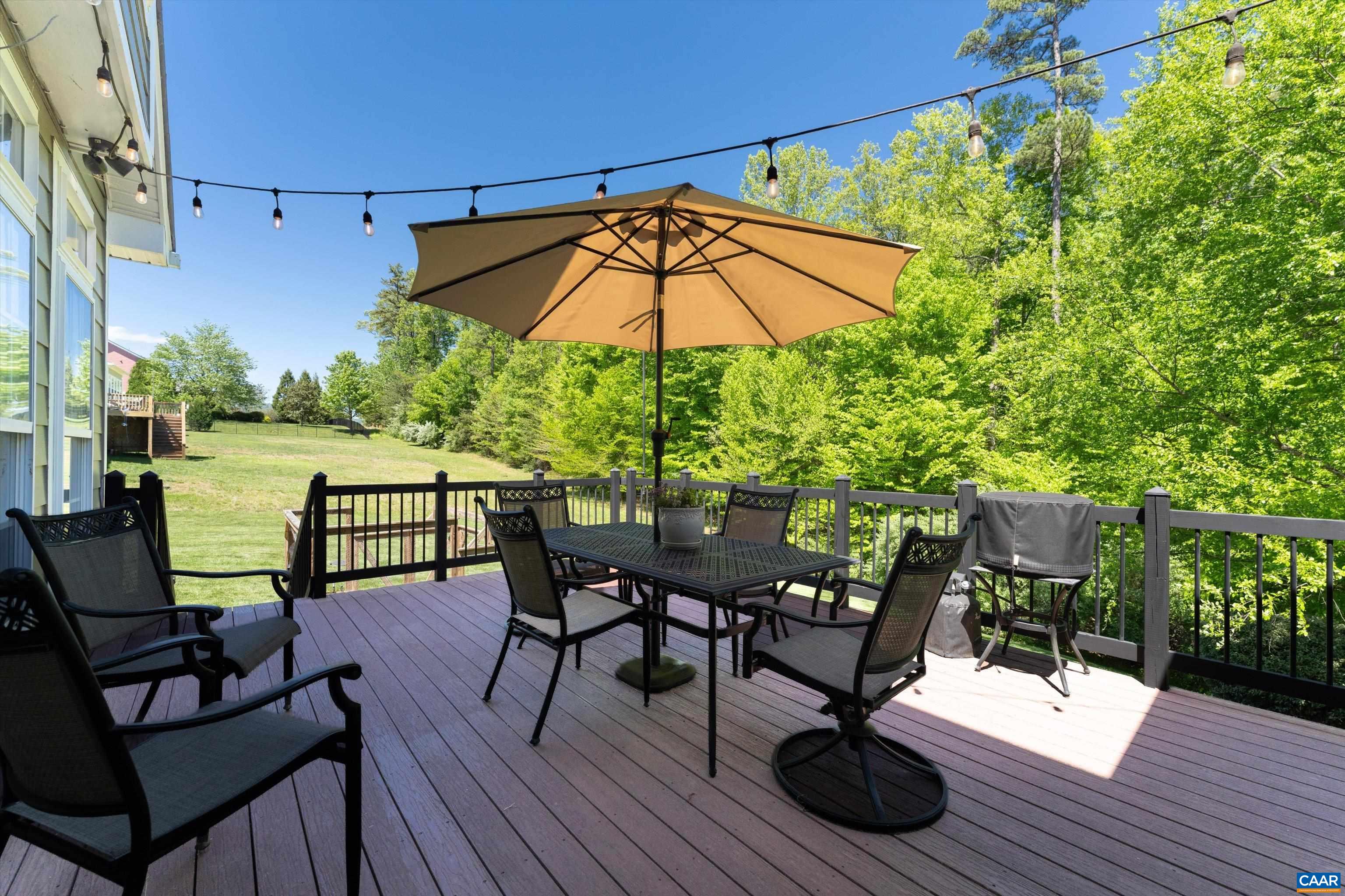 5366 Park Road Crozet, VA 22932 - Photo 10 of 61 a view of a roof deck with table and chairs under an umbrella with wooden floor