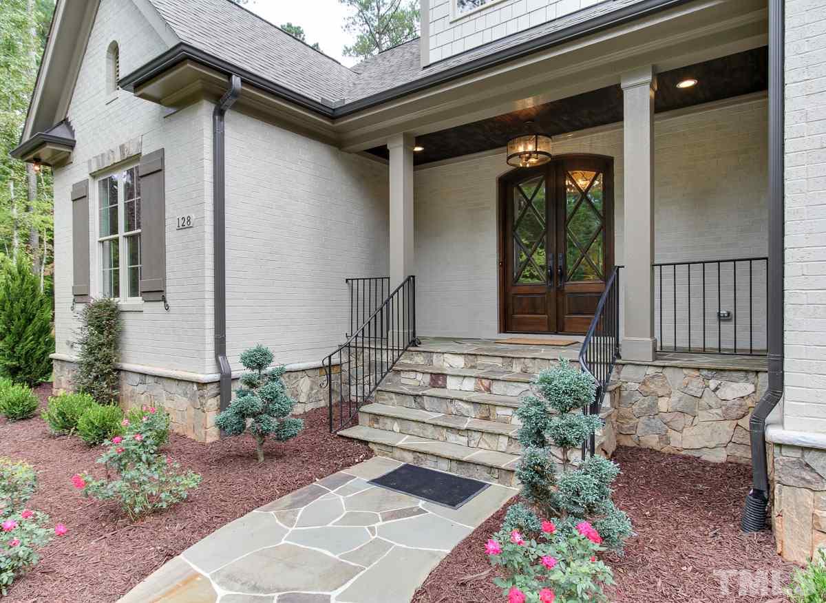 128 Chatterson Drive Raleigh, NC 27615 - Photo 2 of 25 a view of a house with wooden walls and flower plants