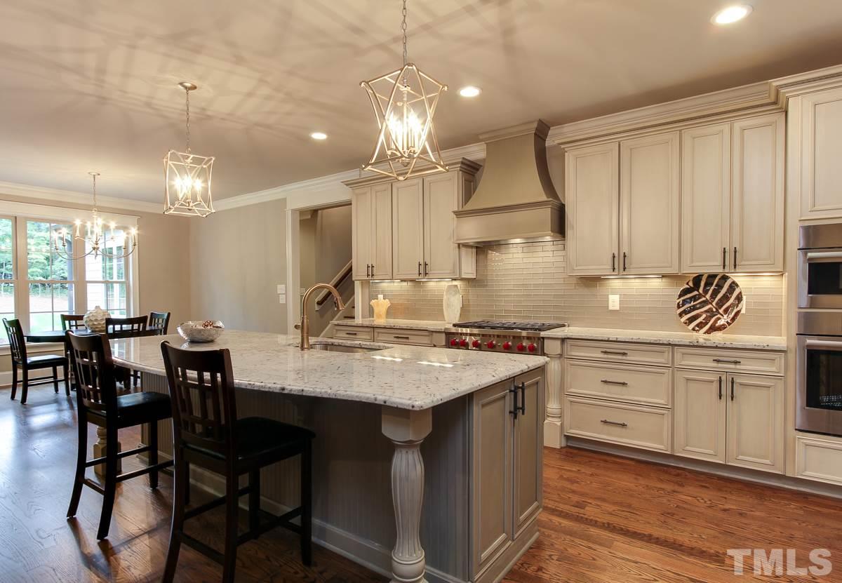 128 Chatterson Drive Raleigh, NC 27615 - Photo 7 of 25 a kitchen with center island table and chairs in it