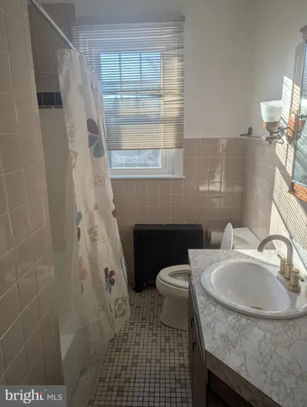 a bathroom with a sink a toilet and a window