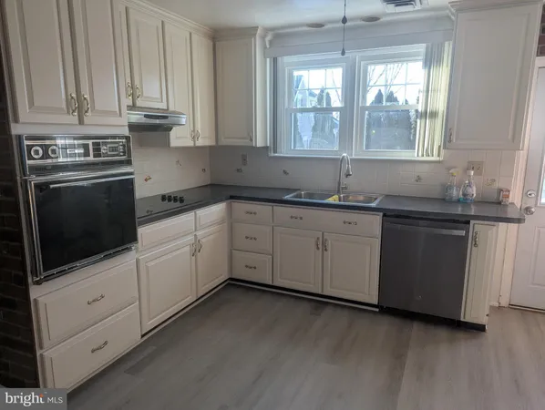 a kitchen with granite countertop white cabinets and white appliances