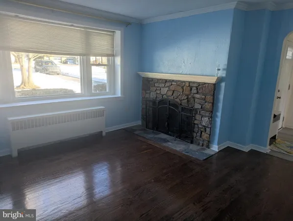 a living room with wooden floor and a fireplace