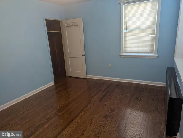 an empty room with wooden floor and window