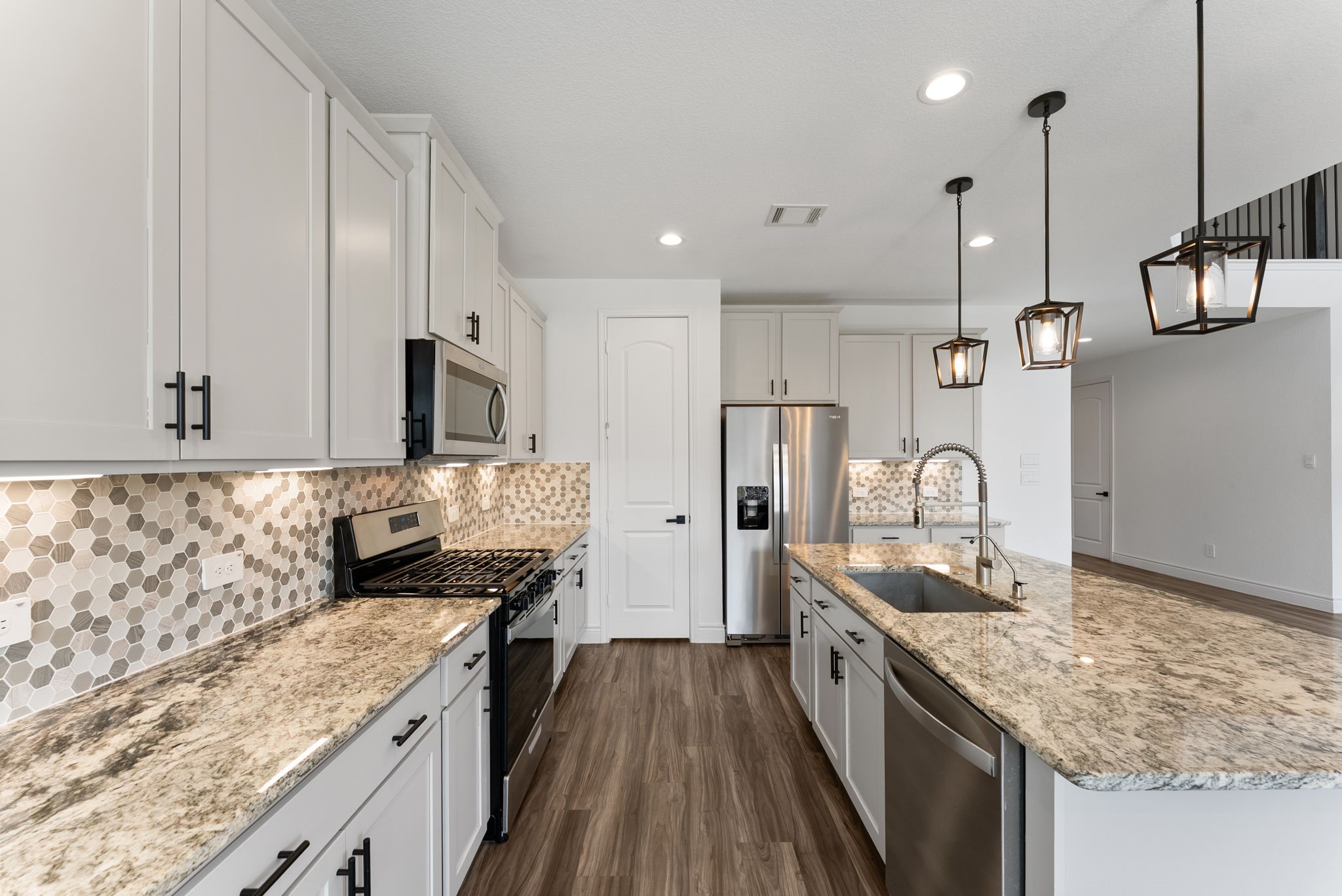 20151 Clear Rdg Lane Montgomery, TX 77316 - Photo 15 of 39 a kitchen with stainless steel appliances granite countertop a sink a stove and a wooden floors