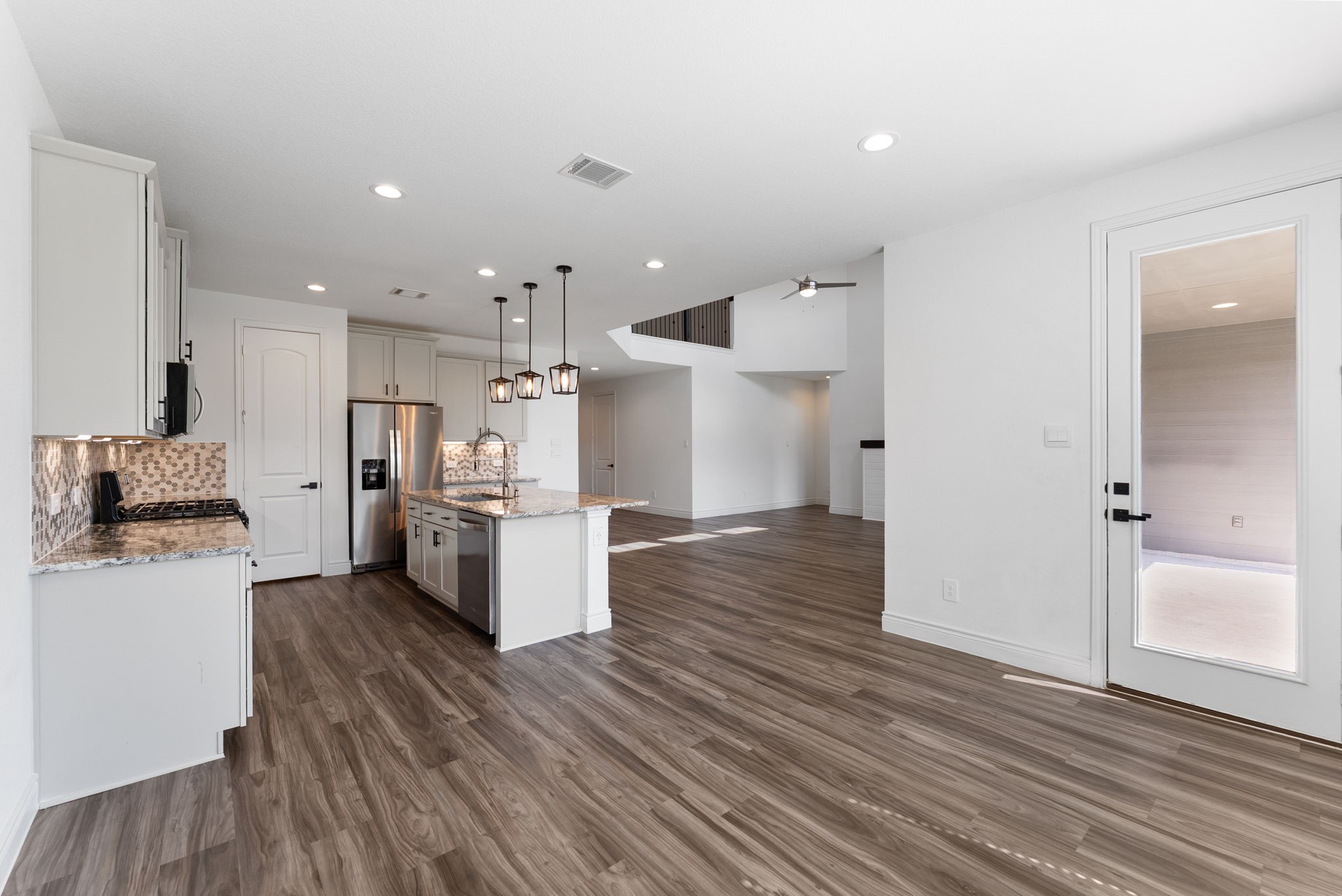 20151 Clear Rdg Lane Montgomery, TX 77316 - Photo 19 of 39 a kitchen with stainless steel appliances kitchen island wooden floors and white cabinets