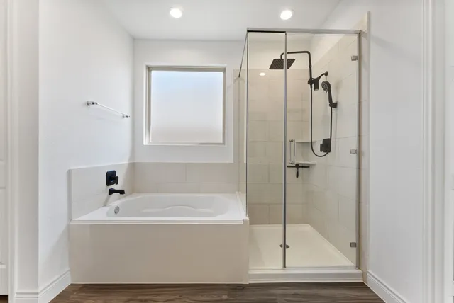 a white bath tub sitting next to a shower