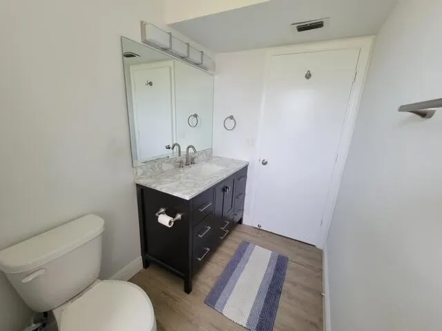 a bathroom with a sink vanity mirror and toilet