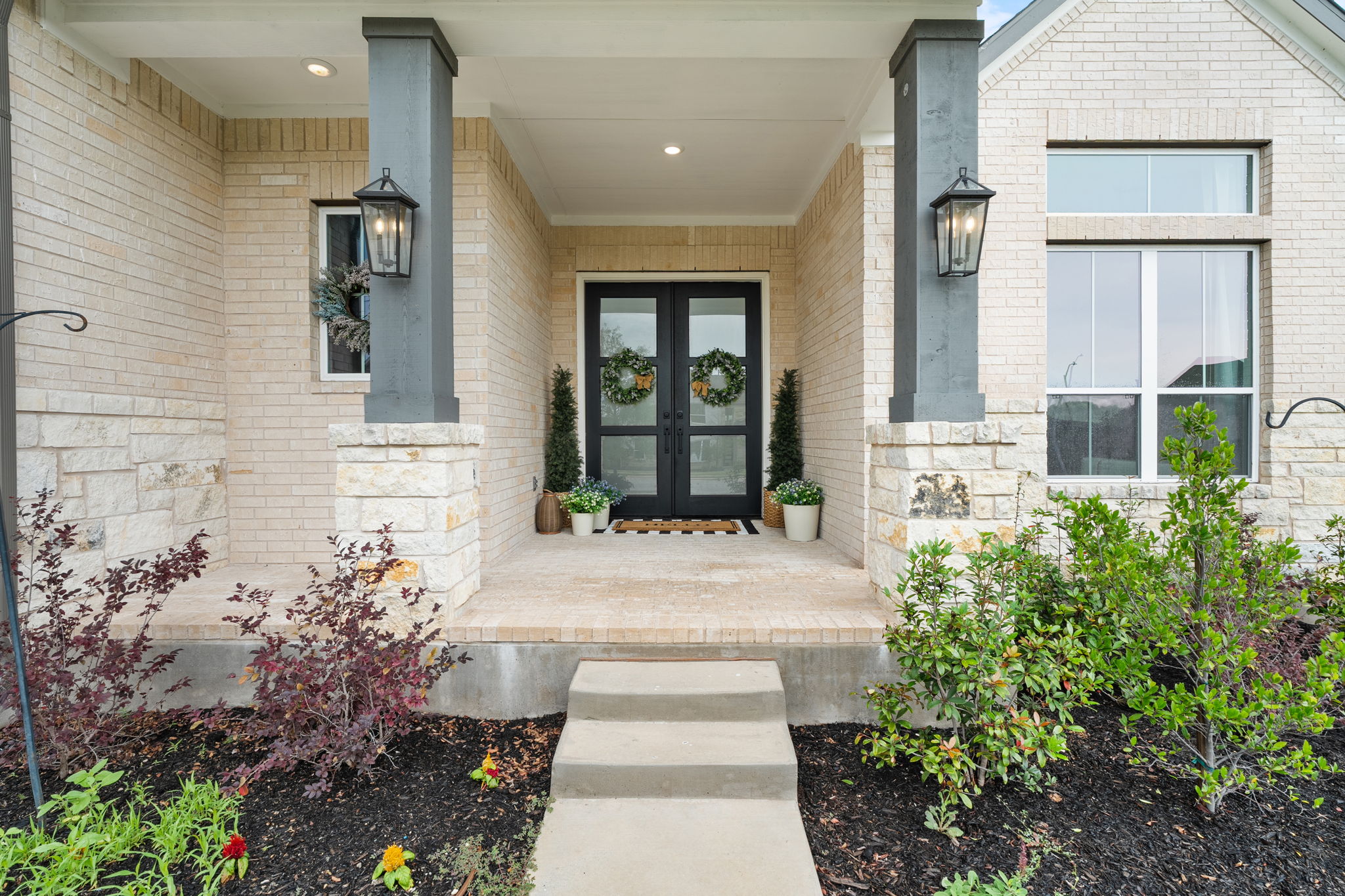 515 Watershield Cove Georgetown, TX 78633 - Photo 4 of 40 A welcoming stone and brick facade features prominent double doors flanked by tasteful landscaping and inviting outdoor lighting.