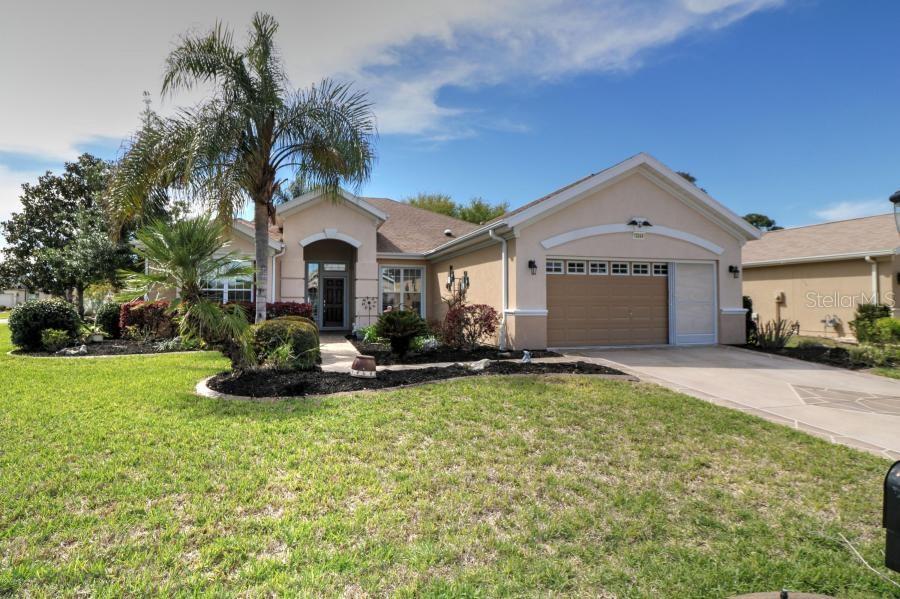 13044 Southeast 90th Court Road Summerfield, FL 34491 - Photo 1 of 1 a front view of a house with a yard and garage