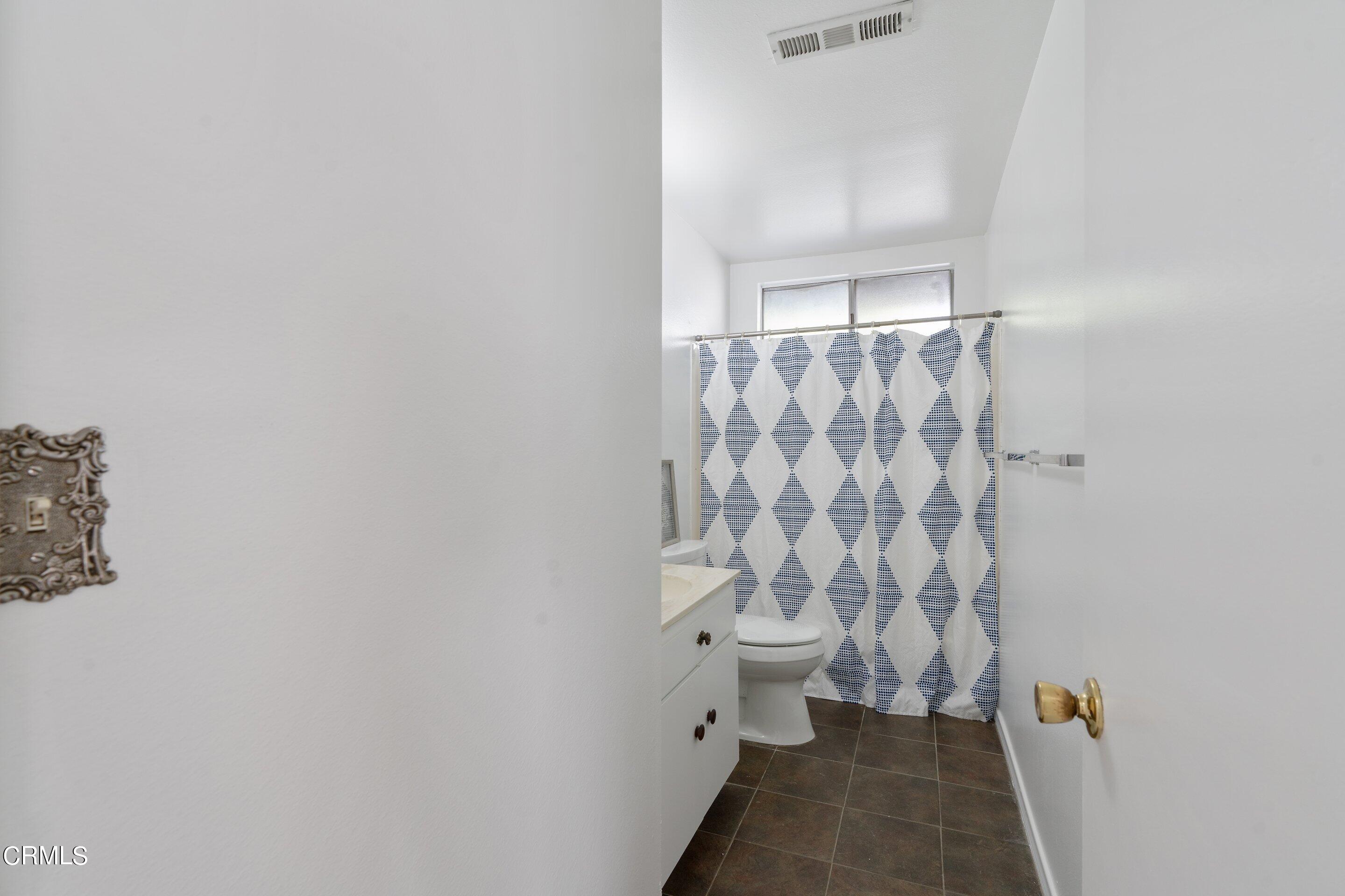 575 Winona Way Pasadena, CA 91103 - Photo 22 of 36 a bathroom with a toilet and a shower curtain