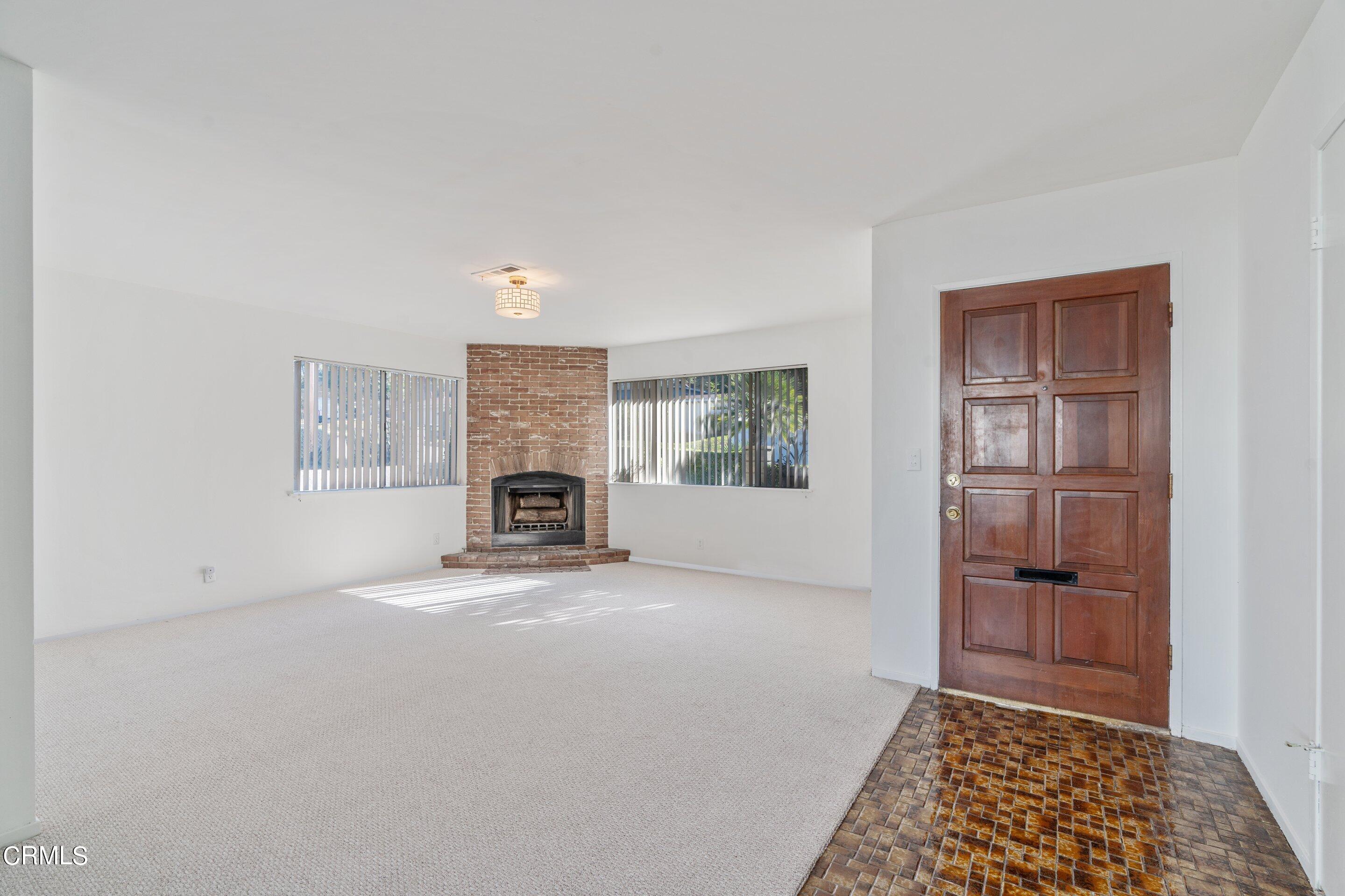 575 Winona Way Pasadena, CA 91103 - Photo 8 of 36 a view of an empty room with a fireplace and a window