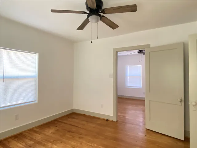 an empty room with a window and a ceiling fan